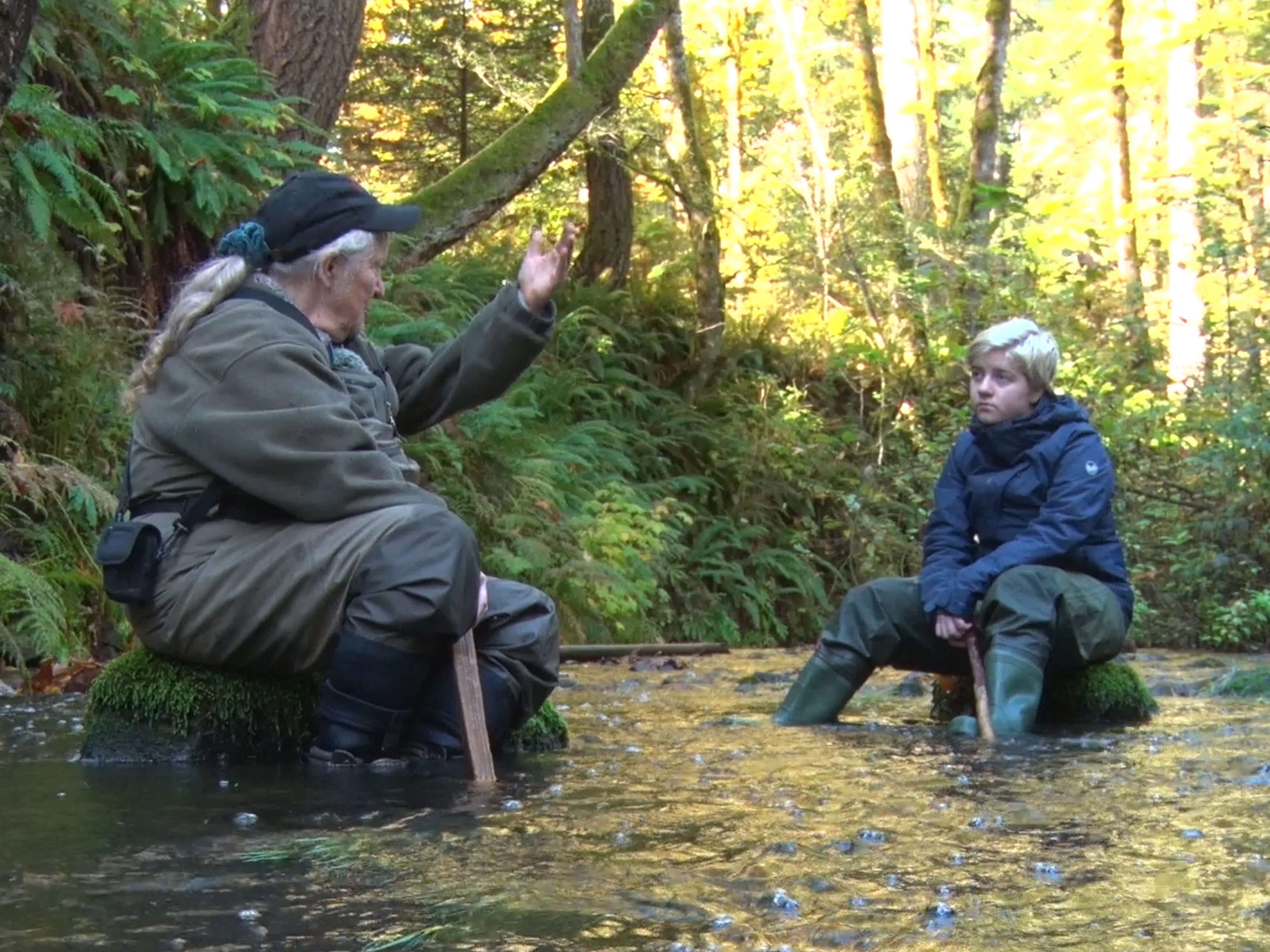 Teacher and student sitting in a stream.  Photo Credit Ed Carswell